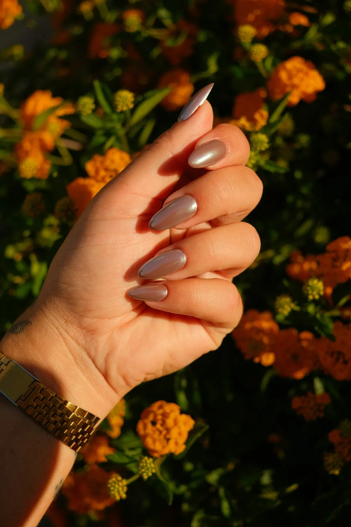 Unhas nude ao lado de flores